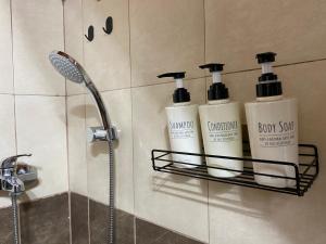 a bathroom with three bottles of soap and a shower at Villa Archontissa in Kavros