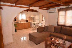 a living room with a couch and a kitchen at Villa Archontissa in Kavros