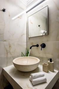 a bathroom with a bowl sink on a counter at Porto Del Colombo Traditional Boutique Hotel in Chania