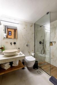 a bathroom with a shower and a toilet and a sink at Porto Del Colombo Traditional Boutique Hotel in Chania