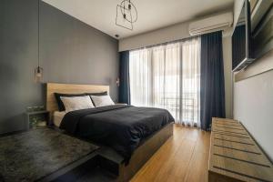 een slaapkamer met een bed en een groot raam bij Super Stylish Apartments in the Heart of Athens! in Athene