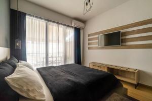 1 dormitorio con cama y ventana grande en Super Stylish Apartments in the Heart of Athens!, en Atenas