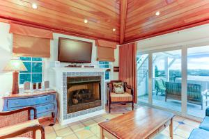 a living room with a fireplace and a tv at Ocean Ave Seaside Cottage in Fernandina Beach