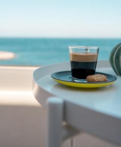 een kop koffie en een koekje op een tafel bij Résidences Sopramare in Algajola