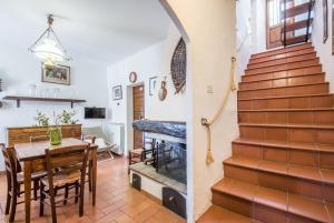 a living room with a staircase and a dining room with a table at Casa Francesca in Montalcino