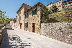 a stone building with a car parked on a street at Casa Francesca in Montalcino