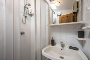 a white bathroom with a sink and a shower at Casa Francesca in Montalcino +17 photos