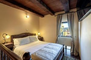 a bedroom with a bed and a large window at Porto Del Colombo Traditional Boutique Hotel in Chania