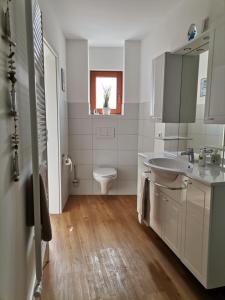 a white bathroom with a sink and a toilet at Ferienwohnung Neukalen in Neukalen