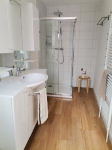 a white bathroom with a shower and a sink at Ferienwohnung Neukalen in Neukalen
