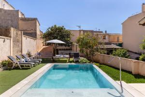 a small swimming pool in a yard with a patio at Casa Magui in Capdepera