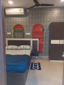 1 dormitorio con 1 cama y 2 sillas rojas y verdes en Ani's Homestay en Calcuta