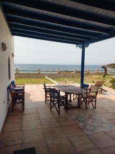 a patio with a table and chairs and the ocean at Λακεδαιμονία in Paralia Demonias