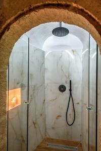 a bathroom with a shower with a glass door at Porto Del Colombo Traditional Boutique Hotel in Chania