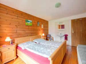 a bedroom with a wooden wall with a bed at Scenic Apartment in Tirol with Garden in Kaltenbach