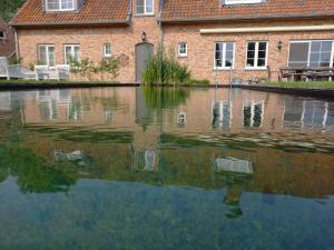 a reflection of a building in a body of water at Vakantiewoning Victors Hof tot 4 pers in Lievegem