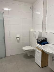 a white bathroom with a toilet and a sink at Schöne 3 Zimmer Wohnung Mitten in Bad Rothenfelde! in Bad Rothenfelde +9 photos