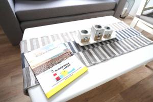 a coffee table with two books and cups on it at Ferienwohnung Spiekeroog in Neuharlingersiel