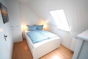 Dormitorio pequeño con cama y ventana en Ferienwohnung Spiekeroog, en Neuharlingersiel