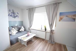 ein Wohnzimmer mit einer Couch und einem Fenster in der Unterkunft Ferienwohnung Langeoog in Neuharlingersiel