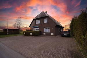 ein Haus mit einem in einer Einfahrt geparkten Auto in der Unterkunft Ferienwohnung Langeoog in Neuharlingersiel