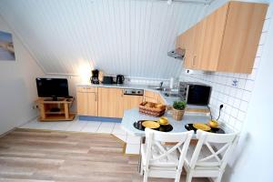 eine Küche mit einem Tisch und Stühlen in einer Küche in der Unterkunft Ferienwohnung Langeoog in Neuharlingersiel