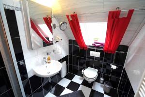 ein schwarzweißes Bad mit einem Waschbecken und einem WC in der Unterkunft Ferienwohnung Langeoog in Neuharlingersiel