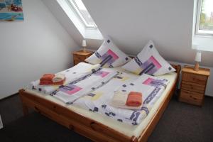 een slaapkamer met een bed met witte lakens en kussens bij Ferienwohnung Skipper in Dornumersiel