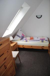 een slaapkamer met een bed en een stoel op zolder bij Ferienwohnung Skipper in Dornumersiel