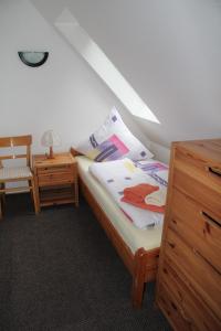 een slaapkamer met een bed met een dressoir en een stoel bij Ferienwohnung Skipper in Dornumersiel