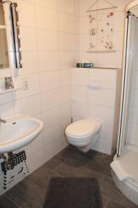 een badkamer met een toilet en een wastafel bij Ferienwohnung Skipper in Dornumersiel