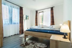 una camera da letto con un letto e una grande finestra di Pensiunea Farmecul Naturii și căsuțe individuale de închiriat Colibița a Colibiţa Altre 58 foto