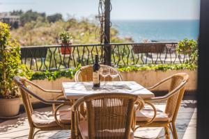 a table and chairs on a patio with a view of the ocean at Hotel & Apartments HEC Residence in Sveti Stefan