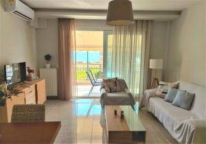 a living room with a couch and a coffee table at Myrsini’s sea view apartment in Nea Peramos