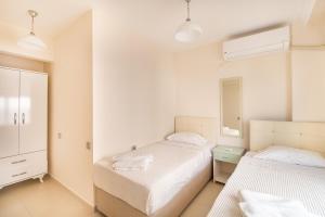 a bedroom with two beds and a dresser and a mirror at Apartments Near to City Center and Beach in Marmaris