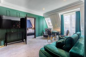 a living room with a green couch and a television at Monte Carlo Boutique Hotel in Świnoujście