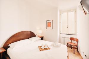 - une chambre avec un lit blanc et une chaise dans l'établissement Appartamento fronte mare a Ospedaletti by Wonderful Italy, à Ospedaletti