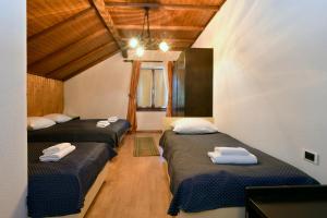 a room with three beds in a room at Gostilna Lokve in Lokve