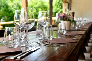 a long wooden table with wine glasses on it at Gostilna Lokve in Lokve
