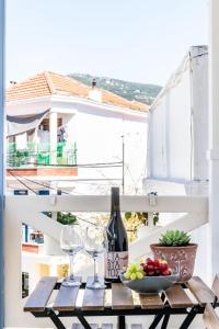 einen Tisch mit einer Flasche Wein und einer Schale Obst in der Unterkunft Jasmine guesthouse in Skopelos