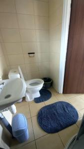 La salle de bains est pourvue de toilettes, d'un lavabo et de 2 tapis. dans l'établissement Domek Wilamów, à Wilamów