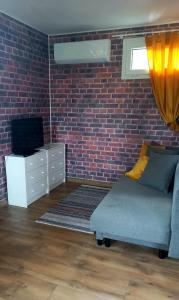 - un salon avec un canapé et un mur en briques dans l'établissement Domek Wilamów, à Wilamów