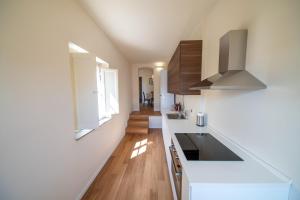 a kitchen with white counters and wooden floors at VILLA CITTADELLA in Lucca