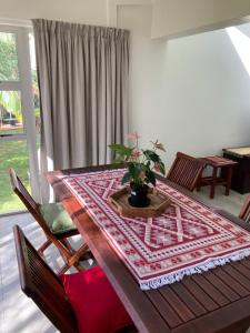 a dining room table with a potted plant on it at The Bridge 19 - Self Catering in St Lucia
