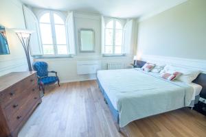 a bedroom with a bed and a dresser and windows at VILLA CITTADELLA in Lucca