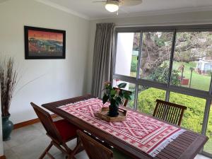 a dining room with a table with a plant on it at The Bridge 19 - Self Catering in St Lucia