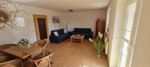 a living room with a blue couch and a table at Am Walde in Trassenheide