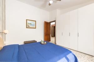 a bedroom with a blue bed with a blue blanket at Coastal Home in Santa Maria Navarrese