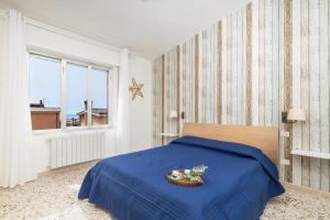 a bedroom with a blue bed and a window at Coastal Home in Santa Maria Navarrese