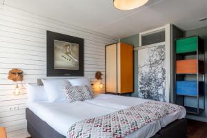 ein Schlafzimmer mit einem großen weißen Bett in einem Zimmer in der Unterkunft Strandhotel Westduin in Koudekerke